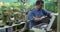 Caucasian male gardener taking care of bonsai tree at garden center