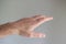 Caucasian male hand making generic gesture. Close up shot, opened palm, isolated on gray background