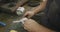 Caucasian male hands factory worker at a factory sitting at a workbench and working on a metal