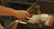 Caucasian male hands factory worker at a factory standing at a workbench and using a hummer