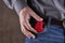 caucasian male person holds heart symbol at blue jeans pocket. copy space