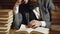 Caucasian male reading, turning the book pages, a bunch of book in the table. Bearded man reading book on wooden table