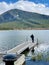 Caucasian male standing on the edge of a dock on Lake Minnewanka in Banff National Park, Canada