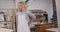 Caucasian male surfboard maker putting on a protective apron in his studio