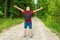 Caucasian male tourist in forest with arms wide open. Copy space.Man backpacker arms outstretched in forest.Summer day