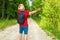 Caucasian male tourist in forest with arms wide open. Copy space.Man backpacker arms outstretched in forest.Summer day