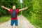 Caucasian male tourist in forest with arms wide open. Copy space.Man backpacker arms outstretched in forest.Summer day