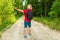 Caucasian male tourist in forest with arms wide open. Copy space.Man backpacker arms outstretched in forest.Summer day