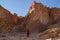 Caucasian male traveler in a red T-shirt posing against the backdrop of a sandy rock in the Timna National Park, Israel