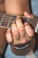 A Caucasian males hands playing an acoustic guitar