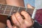 A Caucasian males hands playing an acoustic guitar