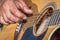 A Caucasian males hands playing an acoustic guitar