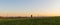 Caucasian man from back looking to industrial part of city Ceske Budejovice on meadow at sunset. Czech republic