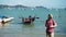 Caucasian man with bandana covering his face pilots drone standing on the coast of sea port