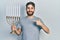 Caucasian man with beard holding menorah hanukkah jewish candle smiling happy pointing with hand and finger
