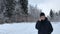 Caucasian man with a beard in the winter walks in the woods and talking on the phone.