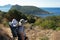 Caucasian man carrying backpack with baby wearing sunhat, travelling in beautiful places in nature in summer sunny