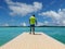 Caucasian man - cyclist in helmet - standing on a landing stage at lake.