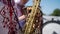 A caucasian man in an embroidered shirt plays wind musical instrument saxophone