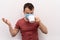 Caucasian man in facial surgical medical protective mask tries to drink coffee