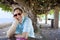 Caucasian man in forties relaxing under shaded tree canopy