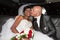 Caucasian man groom kissing her charming wife bride black african in luxury wedding car