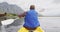 Caucasian man having a good time on a trip to the mountains, kayaking on a lake, holding a paddle