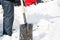 Caucasian man holds a shovel to help remove snow from the road