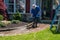 A Caucasian man with a latex holding water sprayer wand power washing the brick walkway to a house