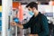 Caucasian man is making a transaction at an automated kiosk to purchase public transport tickets