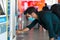 Caucasian man is making a transaction at an automated kiosk to purchase public transport tickets