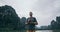 Caucasian man overlooking limestone mountains in Ninh Binh province, Vietnam. Cloudy day