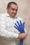 Caucasian man puts a blue cloth glove on his hand, prepares for work. Hand protection concept, health protection