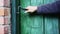 Caucasian man\'s hand closes a wooden door in a house locked on a hook.