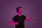 Caucasian man`s portrait isolated on purple studio background in neon light