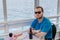 Caucasian man sitting on boat drinking a beer.