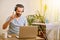 A Caucasian man sitting at a table with a laptop and smiling at the camera. teleworking and home office concept