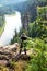 Caucasian man stands with his back turned and making photo of Devils finger at Usvinskie pillars