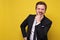 Caucasian man in suit laughing on joke standing on yellow background