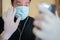 Caucasian man with a surprised expression, wearing gloves and a surgical mask waves to his children during a video call