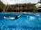 Caucasian man swimming underneath the swimming pool of a tropical holiday villa.