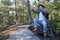 Caucasian man taking photos with his smartphone during a hike around the forest