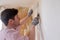 Caucasian man tearing off old wallpaper from wall preparing for home redecoration