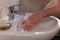 Caucasian man thoroughly washing hands in wash basin under water tap. Personal hygiene as coronavirus COVID-19 pandemic spread