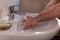 Caucasian man thoroughly washing hands in wash basin under water tap. Personal hygiene as coronavirus COVID-19 pandemic spread