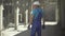 Caucasian man in uniform and helmet walking on concrete manufacturing site with cement mixer truck riding. Male