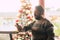 Caucasian man using mobile phone in winter christmas period with tree in background at commercial mall center for shopping and buy