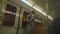 A Caucasian man wearing protective mask uses smartphone while standing at the door of a vintage subway train in Munich