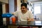 Caucasian man wearing a white T-shirt, pouring some bleach on a mug, following the advice of US President