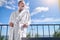 Caucasian man in a white bathrobe standing on the balcony